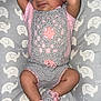 baby, sleeping, crocheted_outfit, hat, booties, pink, gray, elephant_pattern, cushion, infant, peaceful, arms_up, soft_texture, cute, cozy, lying_down, newborn, child, indoors, resting