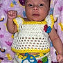 baby, infant, crochet_clothing, blanket, patterned_blanket, colorful, hand, face, eyes, expression, cute, lying_down, indoor, soft_texture, knitted, child, newborn, portrait, raised_fist, closeup