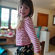 Savannah participe au concours pour gagner de l'argent avec cette photo : child, girl, smiling, indoor, striped_shirt, pink, white, floral_pants, long_hair, happy, portrait, person, home, window, furniture, wooden_chair, casual_clothing, daylight, playful, cute