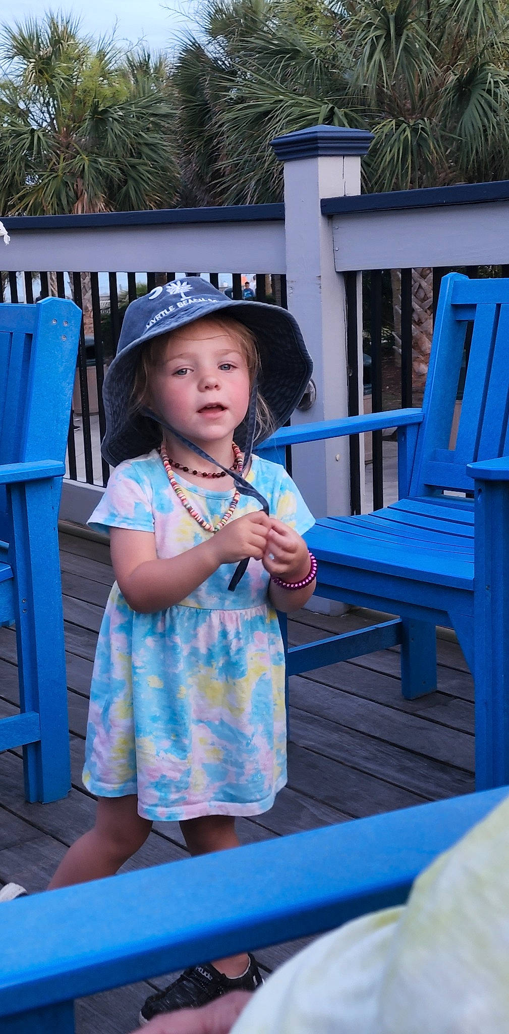Blakelee is registered to the contest to win money with this photo: azure, blue, cap, child, electric_blue, fashion_accessory, fun, hairstyle, happy, hat, headwear, leisure, magenta, outdoor_furniture, person, recreation, shorts, sitting, sun_hat, t_shirt