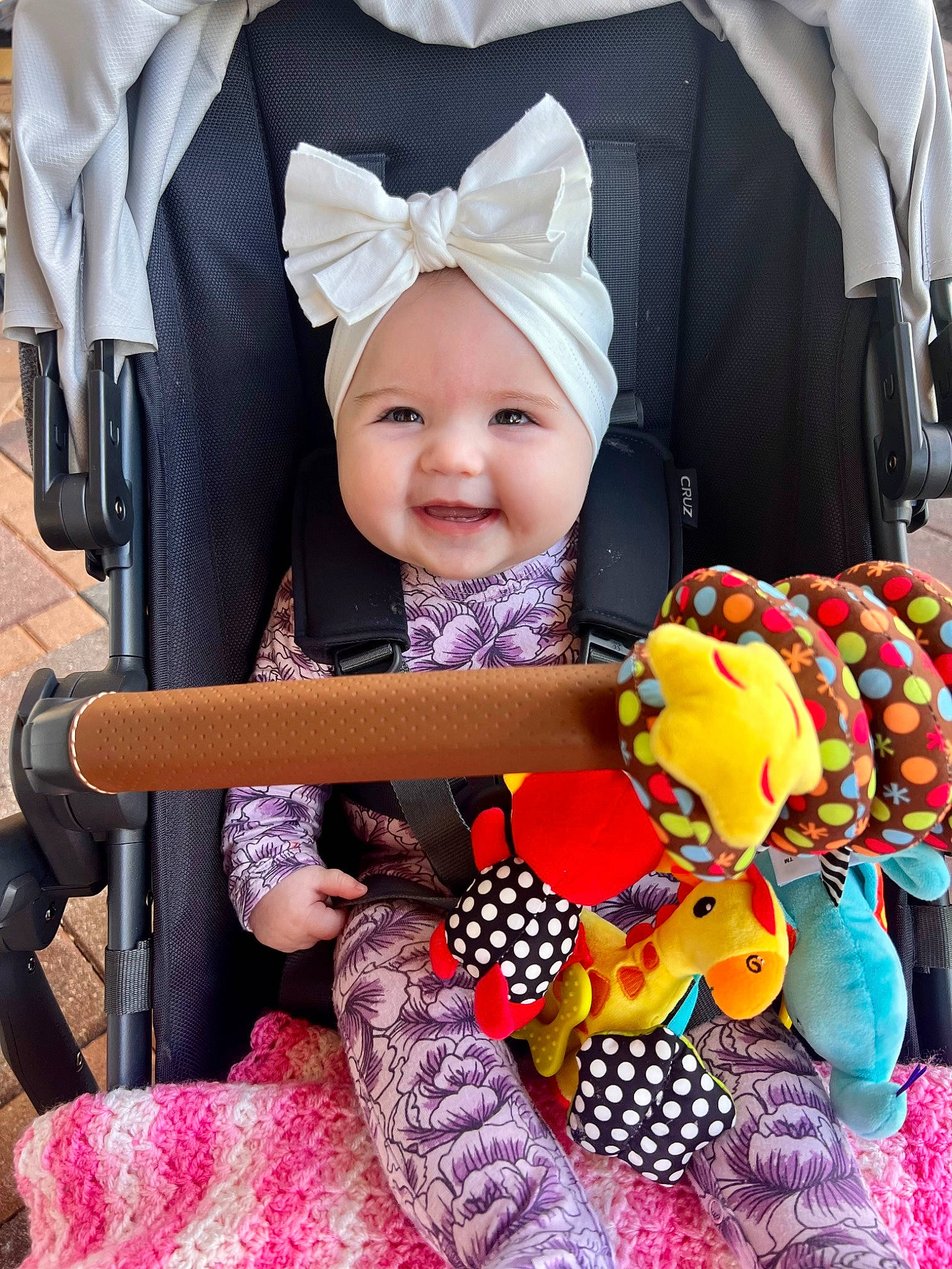 Amelia is registered to the contest to win money with this photo: baby, baby_carriage, baby_products, baby_toddler_clothing, child, comfort, event, eye, fashion_accessory, happy, hat, headwear, joy, person, photograph, pink, product, purple, smile, snapshot