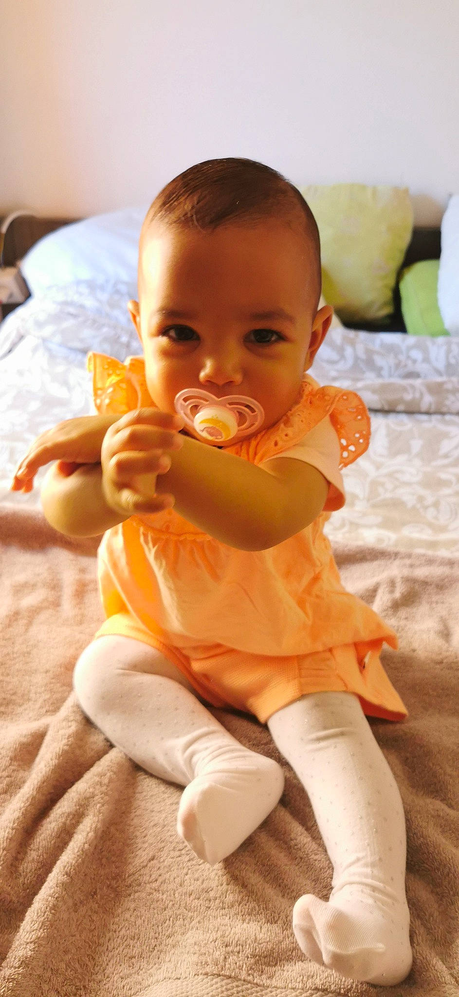 Tessa participe au concours pour gagner de l'argent avec cette photo : arm, baby, baby_toddler_clothing, cheek, comfort, finger, hand, happy, head, human_body, joint, mouth, neck, nose, orange, person, shoulder, skin, sleeve, thigh