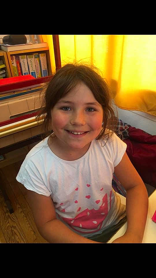 Eva participe au concours pour gagner de l'argent avec cette photo : black_hair, bookcase, cheek, child, chin, eyebrow, forehead, fun, happy, iris, joy, leisure, lip, long_hair, mouth, nose, person, shelf, skin, smile