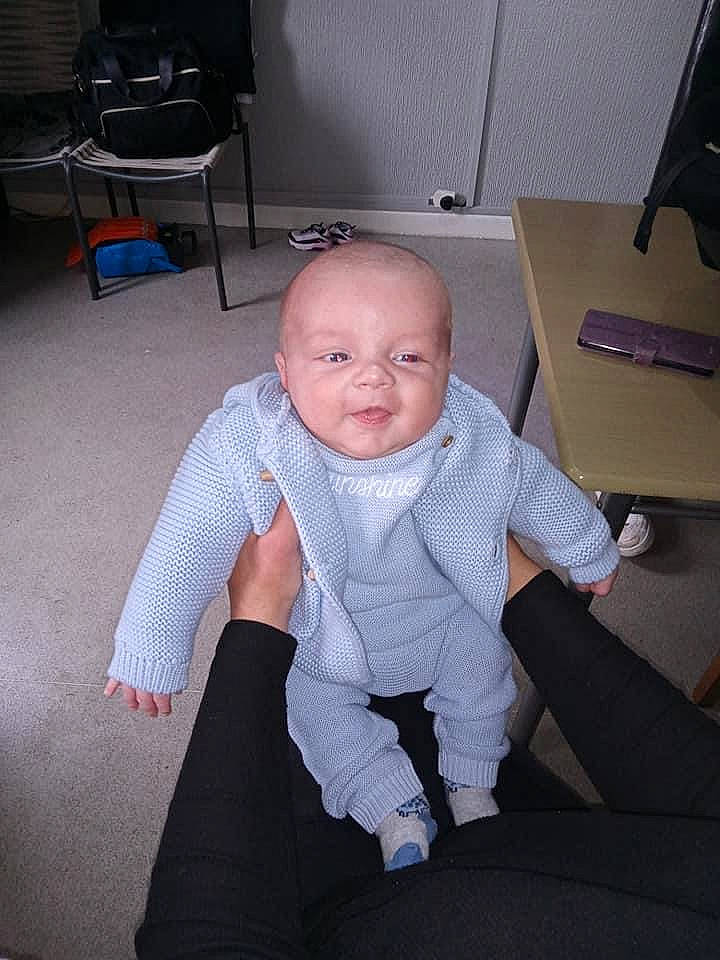 Chester is registered to the contest to win money with this photo: baby, baby_toddler_clothing, chair, chin, comfort, flash_photography, flooring, formal_wear, furniture, happy, knee, lap, person, sitting, sleeve, smile, table, thumb, tie, toddler