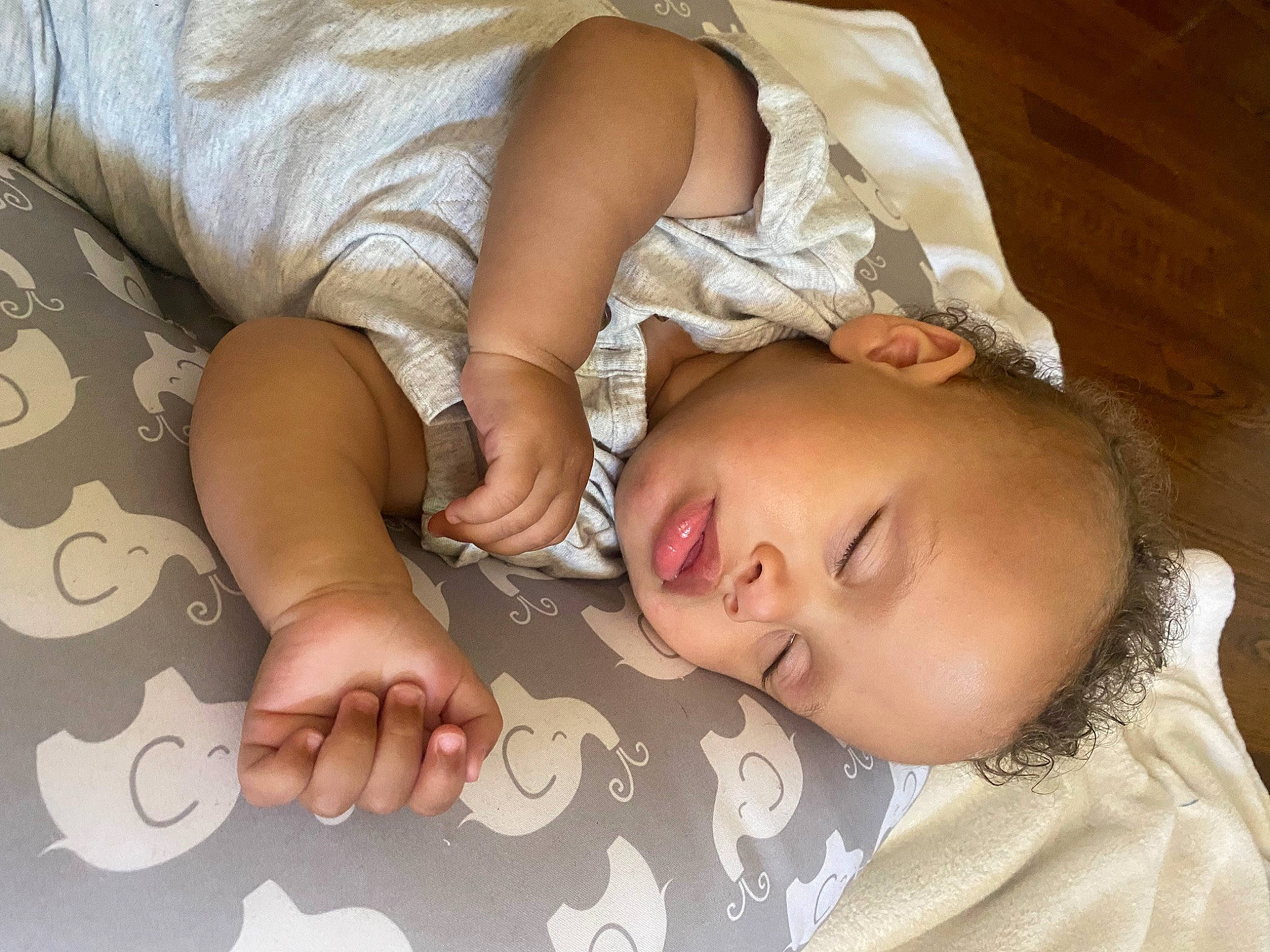 Ronan is registered to the contest to win money with this photo: arm, baby, baby_toddler_clothing, cheek, child, comfort, finger, flooring, gesture, hand, lip, mouth, nail, nose, person, skin, sleeve, textile, toddler, white