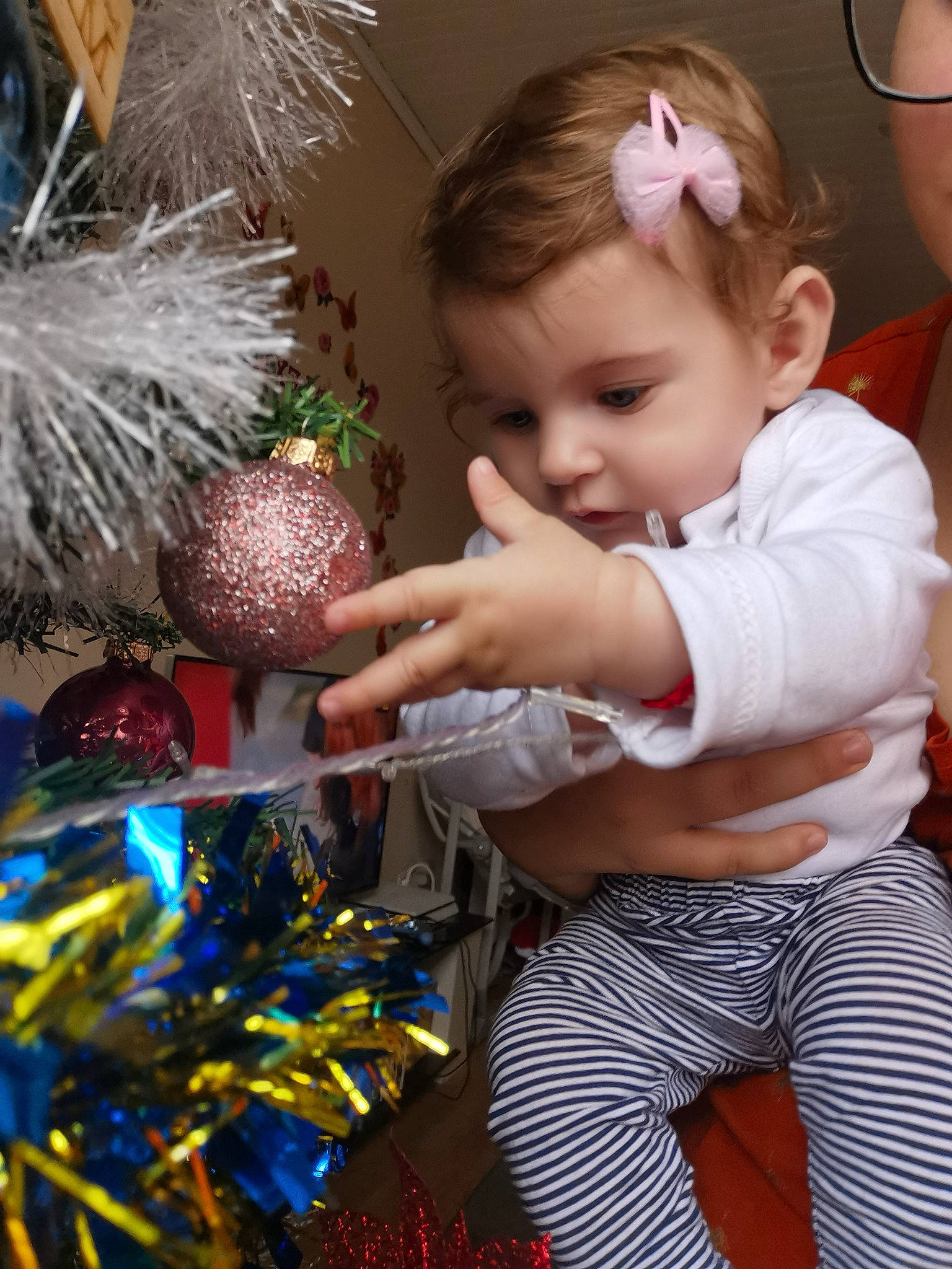 Alexia a rejoint le concours — aidez-le/la à gagner de superbes lots ! baby, baby_toddler_clothing, christmas, christmas_decoration, christmas_eve, christmas_ornament, christmas_tree, conifer, event, facial_expression, fun, happy, holiday, holiday_ornament, interior_design, ornament, party_supply, person, snapshot, toddler