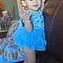 Adhara is registered to the contest to win money with this photo: toddler, child, blue_dress, boots, couch, living_room, pillow, wall_art, smiling, standing, curly_hair, earrings, indoor, furniture, home, cute, playful, happy, person, portrait