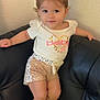 toddler, child, girl, cute, smile, bow, hair, shirt, shorts, shoes, couch, leather, indoor, pose, fashion, golden, white, pink, happy, young
