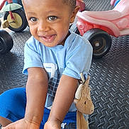 Antonio joined the competition — help win amazing prizes! child, toddler, smiling, blue_shirt, blue_shorts, plush_toy, playground, ride_on_toy, tricycle, floor_mat, outdoor, happy, cute, person, short_hair, toy, play, small_child, reaching_out, closeup