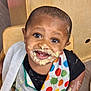 Antonio joined the competition — help win amazing prizes! toddler, child, messy, face, smiling, bib, polka_dot, food, frosting, chair, wood, indoor, happy, cute, portrait, clothing, skin, eyes, mouth, hands