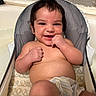 baby, infant, child, smiling, happy, portrait, sitting, bouncer, high_chair, bathroom, bathtub, indoor, bare_chested, diaper, blanket, hand, fist, dark_hair, face, photography