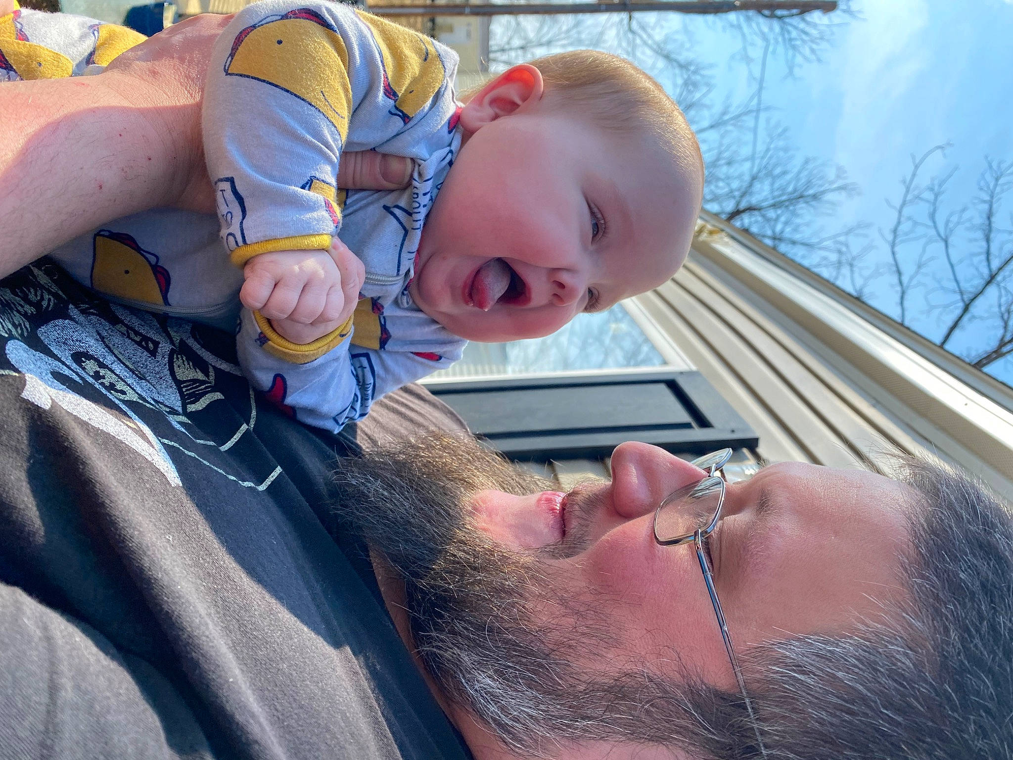 Novah is registered to the contest to win money with this photo: arm, beard, blue, face, gesture, glasses, grass, hand, happy, human_body, interaction, mouth, nose, organ, person, photograph, skin, sky, smile, tree