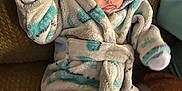 Hailey is registered to the contest to win money with this photo: baby, blanket, child, couch, cozy, cute, expression, home, hooded_robe, indoor, infant, mittens, person, pink_pants, portrait, relaxed, seated, small_hands, soft_fabric, warm_clothing