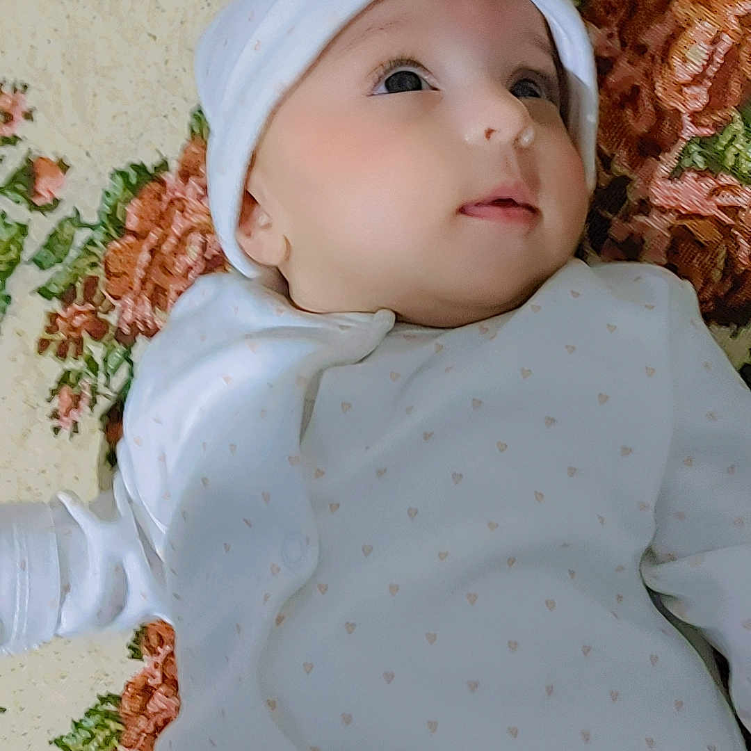Zaira is registered to the contest to win money with this photo: applique, baby, beanie, bonnet, cap, clothing, face, flower, flowerarrangement, flowerbouquet, hat, head, hood, knitwear, newborn, pattern, person, photography, plant, portrait
