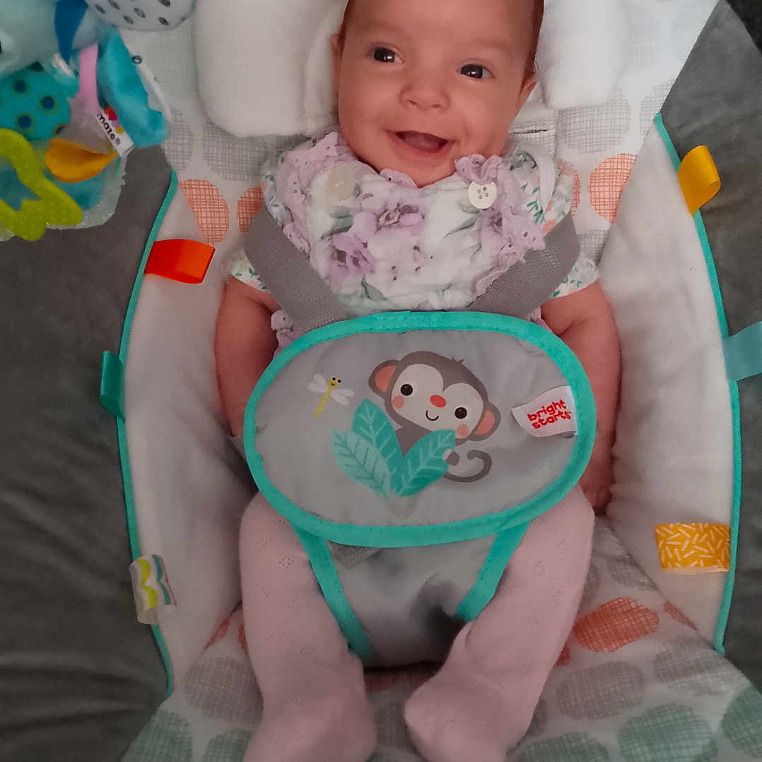 Lainey is registered to the contest to win money with this photo: animal_print, baby, baby_seat, bouncer, child, clothing, colorful, comfort, cute, fabric, happy, head_support, indoor, infant, pastel_colors, playtime, seat, smiling, toy, young_child