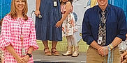 Eliana joined the competition — help win amazing prizes! child, adult, group, stage, school_event, smiling, dress, microphone, backdrop, laptop, chair, boots, tie, lanyard, happy, indoor, people, presentation, decorations, event