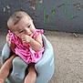 Estella is registered to the contest to win money with this photo: baby, child, pink_dress, baby_seat, gray_seat, sitting, playful, cute, portrait, infant, hand_near_mouth, outdoor, wall, peeling_paint, concrete_floor, happy, young_child, candid, skin, person