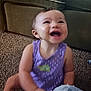Estella is registered to the contest to win money with this photo: toddler, child, smiling, laughing, purple_clothing, carpet, couch, indoor, person, happy, baby, casual, home, furniture, sitting, cute, face, young_child, living_room, joyful