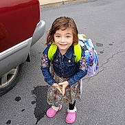 Rosa joined the competition — help win amazing prizes! child, girl, smiling, backpack, denim_jacket, floral_dress, pink_clogs, road, sidewalk, vehicle, tire, grass, outdoor, blue_eyes, long_hair, colorful, casual_clothing, happy, standing, daytime