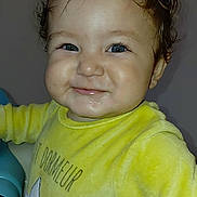 Rayan participe au concours pour gagner de l'argent avec cette photo : baby, blue_eyes, cheeks, child, cozy, curly_hair, cute, face, happy, indoor, infant, person, portrait, sleeves, smile, soft_texture, standing, star, yellow_clothing, young_child
