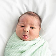 Landon joined the competition — help win amazing prizes! newborn, baby, infant, face, tongue, expression, wrapped, blanket, soft, mint_green, bed, white_background, cute, child, portrait, sleeping_area, skin, head, hair, person