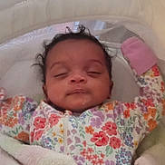 Ember joined the competition — help win amazing prizes! baby, infant, sleeping, blanket, floral_onesie, pink_mitten, bassinet, cushion, cozy, soft, cute, child, peaceful, indoors, portrait, newborn, resting, relaxed, sleepwear, adorable