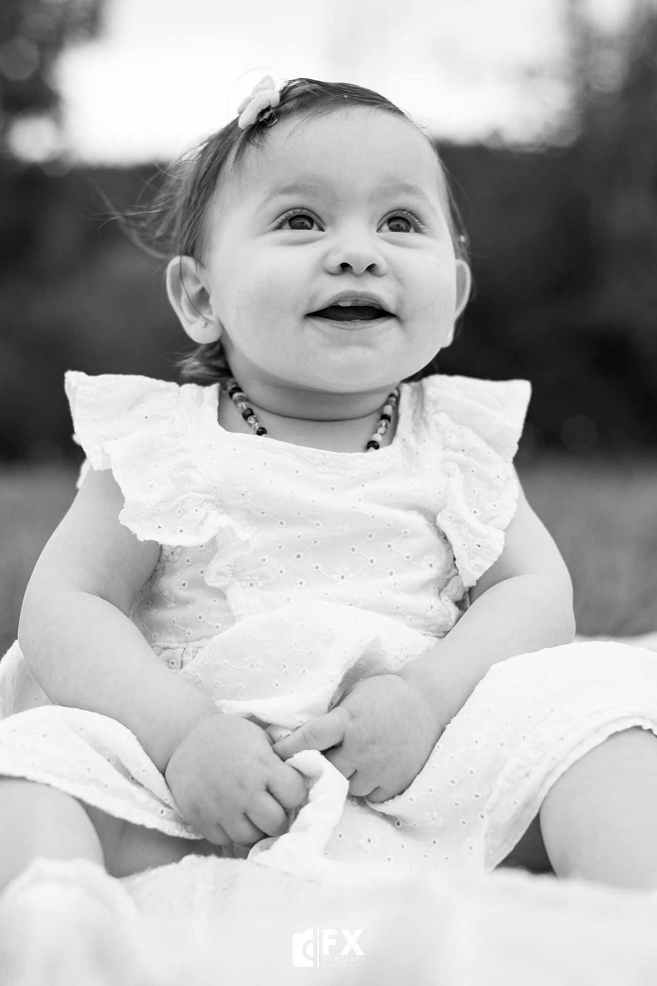 Alba a rejoint le concours — aidez-le/la à gagner de superbes lots ! baby, child, smiling, white_dress, outdoor, portrait, black_and_white, happy, sitting, flower_clip, cute, hands, face, young_child, infant, nature, grass, closeup, photography, ruffles