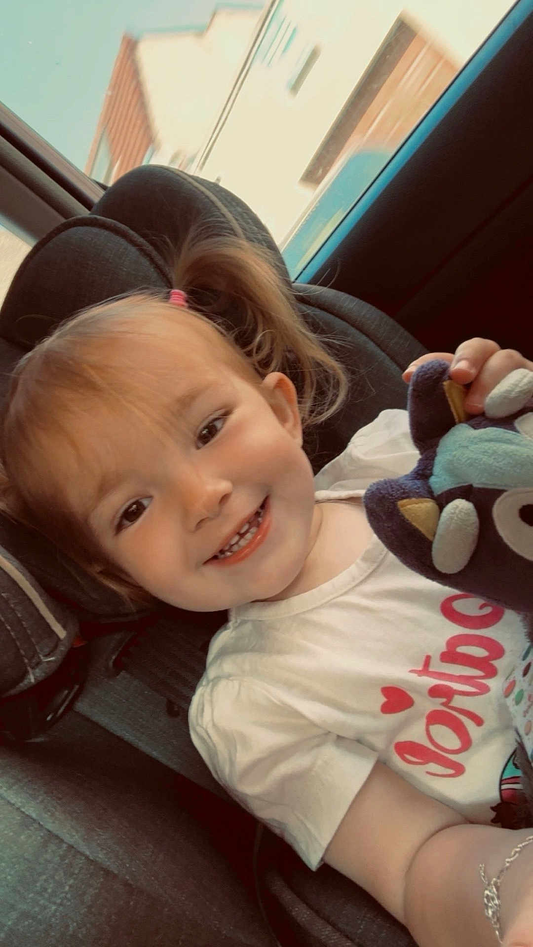 Blanche a rejoint le concours — aidez-le/la à gagner de superbes lots ! bracelet, car_interior, car_seat, casual, child, childhood, cute, daylight, happy, indoors, person, pigtails, plush_toy, portrait, seatbelt, smiling, toddler, toy, white_shirt, young_child