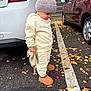 toddler, child, parking_lot, autumn, leaves, car, white_car, red_car, hat, knit_hat, sweatshirt, pants, boots, asphalt, toy, curious, outdoor, side_view, fall, street