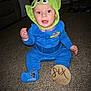 baby, child, infant, costume, hat, alien_hat, blue_outfit, carpet, sign, wooden_sign, six_months, sitting, indoors, living_room, cute, smiling, person, toy_story, disney, sock