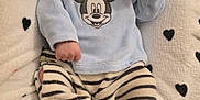 Andréa a rejoint le concours — aidez-le/la à gagner de superbes lots ! baby, crown, blanket, hearts, mickey_mouse, striped_pants, blue_clothing, infant, cute, soft_texture, lying_down, portrait, child, indoors, cozy, small_hands, footed_pants, fabric, pattern, adorable