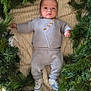 baby, infant, knitwear, greenery, pine_branches, blanket, footwear, shoes, mickey_mouse, lying_down, portrait, indoors, cute, child, holiday, seasonal, cozy, soft_texture, peaceful, newborn