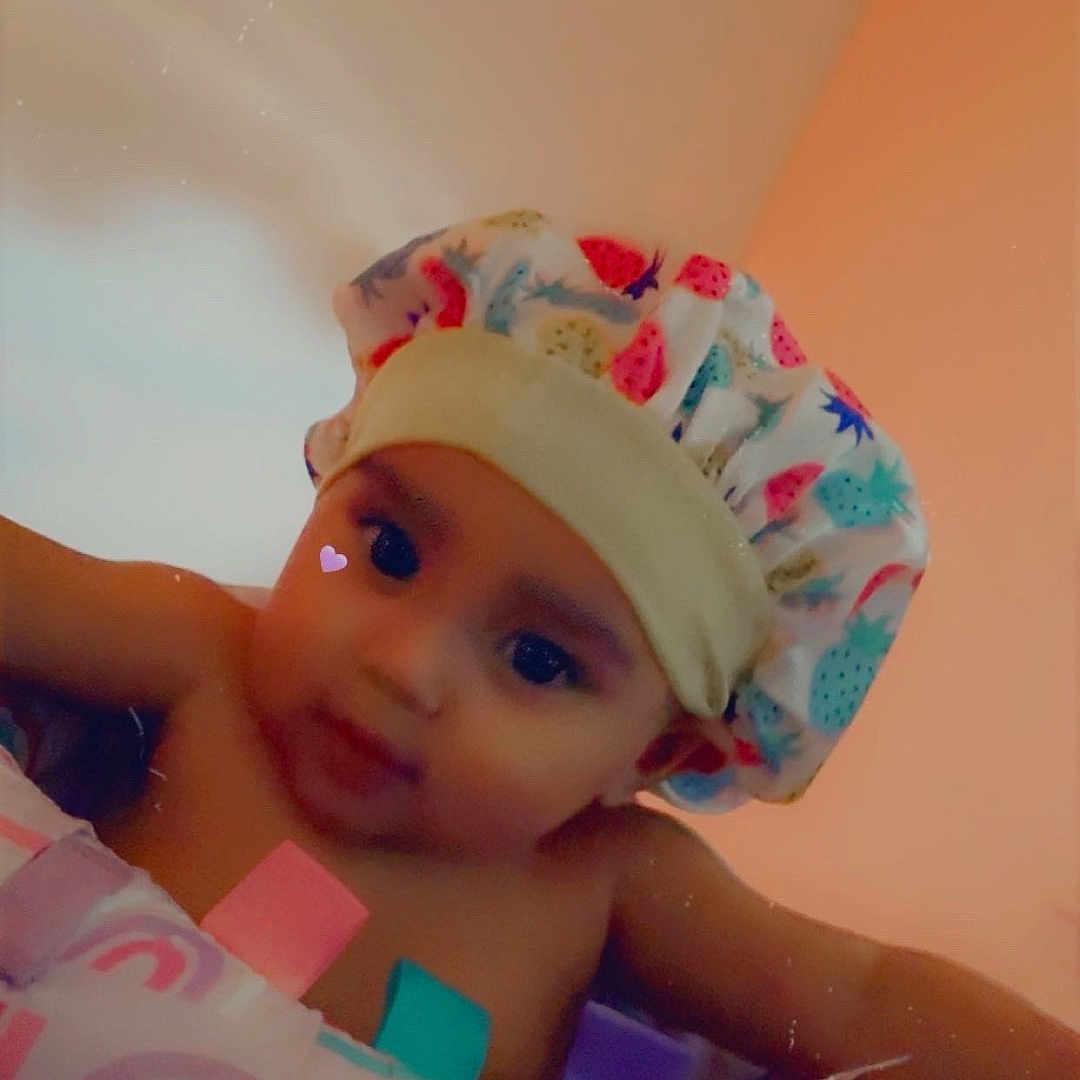 London-Dior joined the competition — help win amazing prizes! baby, child, infant, portrait, smiling, happy, indoor, bath_cap, shower_cap, inflatable_ring, pool_float, colorful, warm_lighting, close_up, face, sitting, playful, heart_sticker, blanket, home