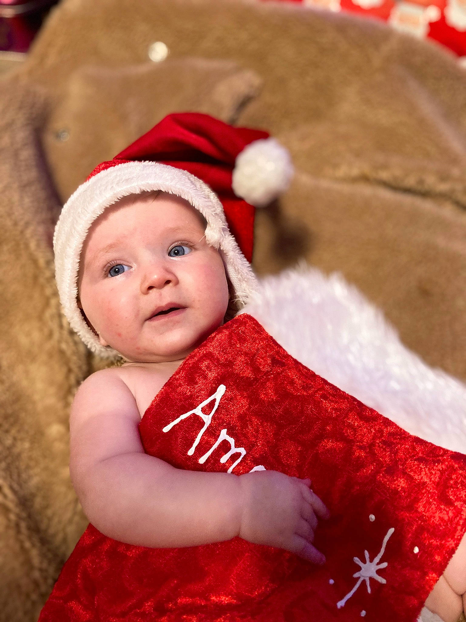 Amari is registered to the contest to win money with this photo: baby, baby_toddler_clothing, cap, christmas, christmas_eve, costume_hat, event, eye, fictional_character, fur_clothing, happy, hat, head, headgear, headwear, holiday, person, red, santa_claus, sleeve