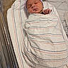 baby, bassinet, bed, blanket, cute, face, hat, hospital, hospital_bed, infant, medical, newborn, newborn_hat, peaceful, person, skin, sleep, sleeping, striped_blanket, swaddled