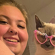 Minnie joined the competition — help win amazing prizes! woman, cat, glasses, heart_shaped_glasses, indoor, smiling, happy, cute, pet, animal, portrait, face, accessory, fashion, funny, closeup, young_adult, light_skin, decor, home