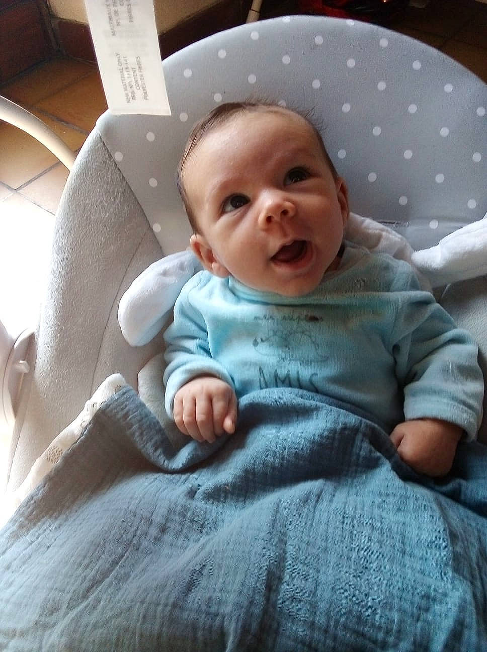 Yves participe au concours pour gagner de l'argent avec cette photo : baby, baby_products, baby_toddler_clothing, cheek, child, comfort, finger, grey, happy, human_body, linens, lip, mouth, nose, person, room, sitting, skin, sleeve, smile