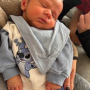 Cameron participe au concours pour gagner de l'argent avec cette photo : baby, newborn, sleeping, infant, person, clothing, blue, white, stitch_character, cartoon, hand, holding, cozy, fabric, sleeve, pajamas, cute, portrait, indoor, resting