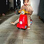 Ambre a rejoint le concours — aidez-le/la à gagner de superbes lots ! child, blue_eyes, curly_hair, hoodie, indoor, toy, scooter, red_toy, floor, playful, smiling, person, young_child, tights, cozy, candid, happy, portrait, furniture, light