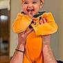 Luna participe au concours pour gagner de l'argent avec cette photo : baby, child, pumpkin_costume, orange, smile, happy, indoor, hands, cute, face, person, costume, holiday, festive, infant, holding, portrait, joyful, celebration, playful