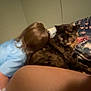 cat, person, bed, indoor, tortoiseshell_cat, animal, feline, brown, blue_clothing, hair, blanket, resting, curious, furniture, closeup, domestic, pet, human, cozy, room
