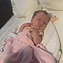 Rowyn is registered to the contest to win money with this photo: baby, blanket, sleeping, infant, bed, pillow, pink, soft, cozy, rest, newborn, child, person, indoors, comfort, cute, peaceful, wrapped, toddler, nap