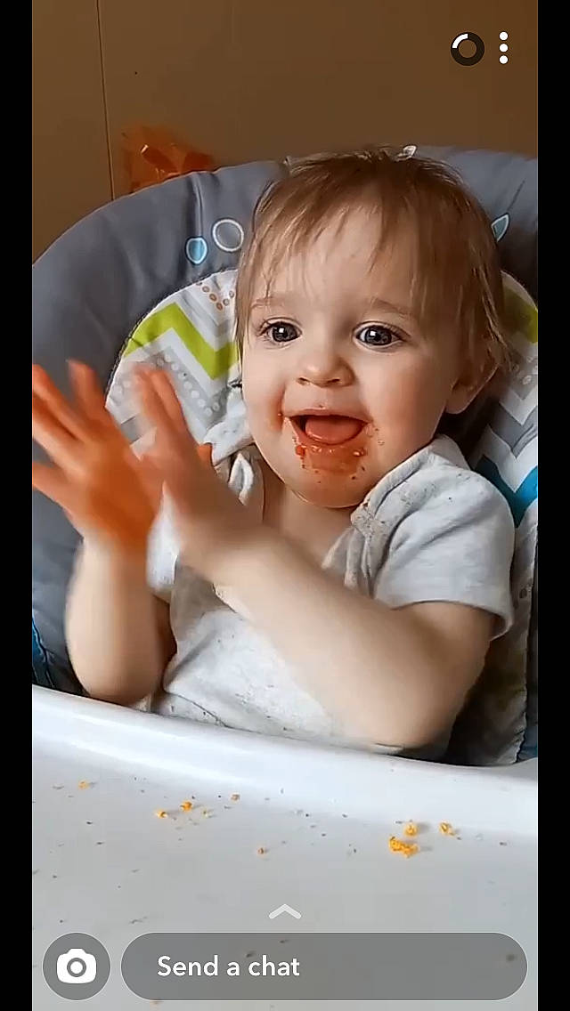 Emmie is registered to the contest to win money with this photo: baby, baby_products, baby_toddler_clothing, bathing, cheek, child, eyelash, finger, fun, gesture, happy, nose, person, room, sitting, sleeve, smile, t_shirt, tableware, thumb