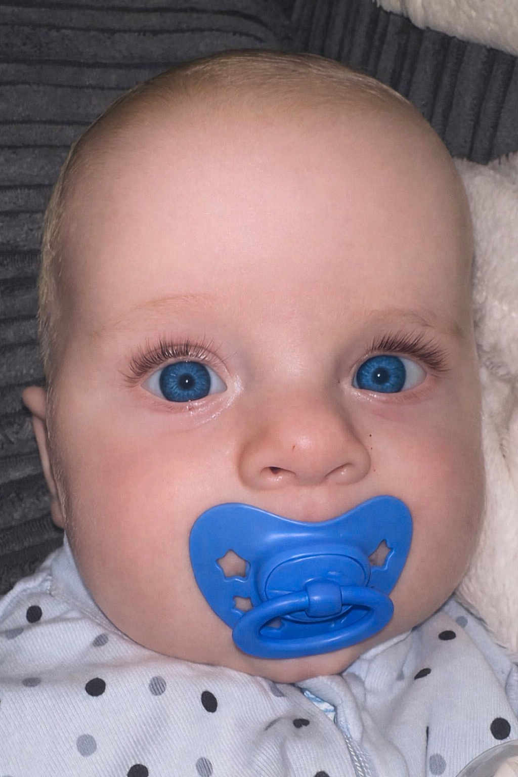 Cody joined the competition — help win amazing prizes! baby, blue_eyes, pacifier, close_up, infant, polka_dot_clothing, long_eyelashes, cute, face, child, newborn, soft_skin, sleepwear, lying_down, indoors, portrait, head, expressionless, baby_girl, baby_boy