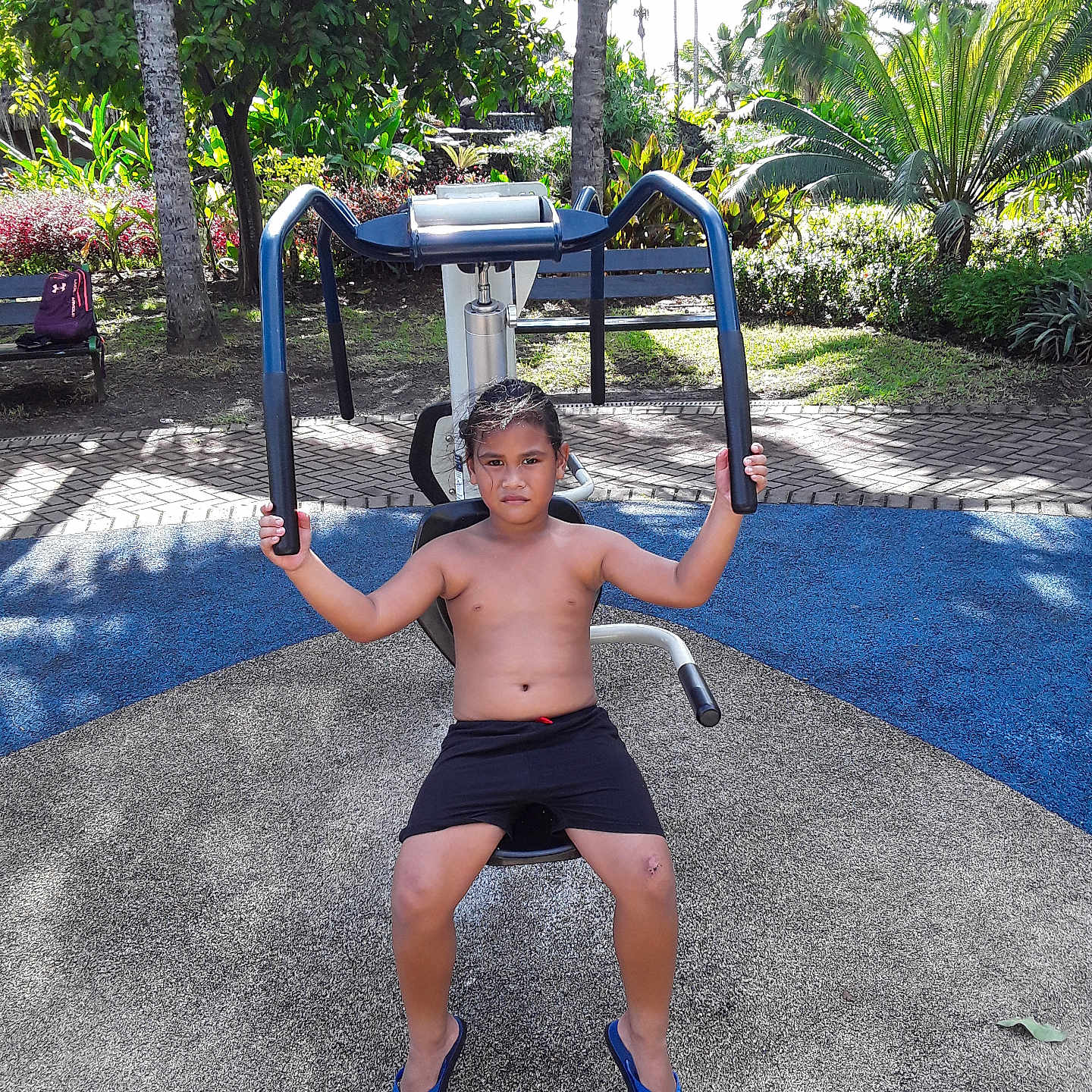 Manaiki participe au concours pour gagner de l'argent avec cette photo : active, boy, casual, child, determined, exercise_machine, fitness, flip_flops, greenery, muscle, outdoor, palm_trees, park, playground, serious_face, shadow, shorts, summer, sunlight, tropical
