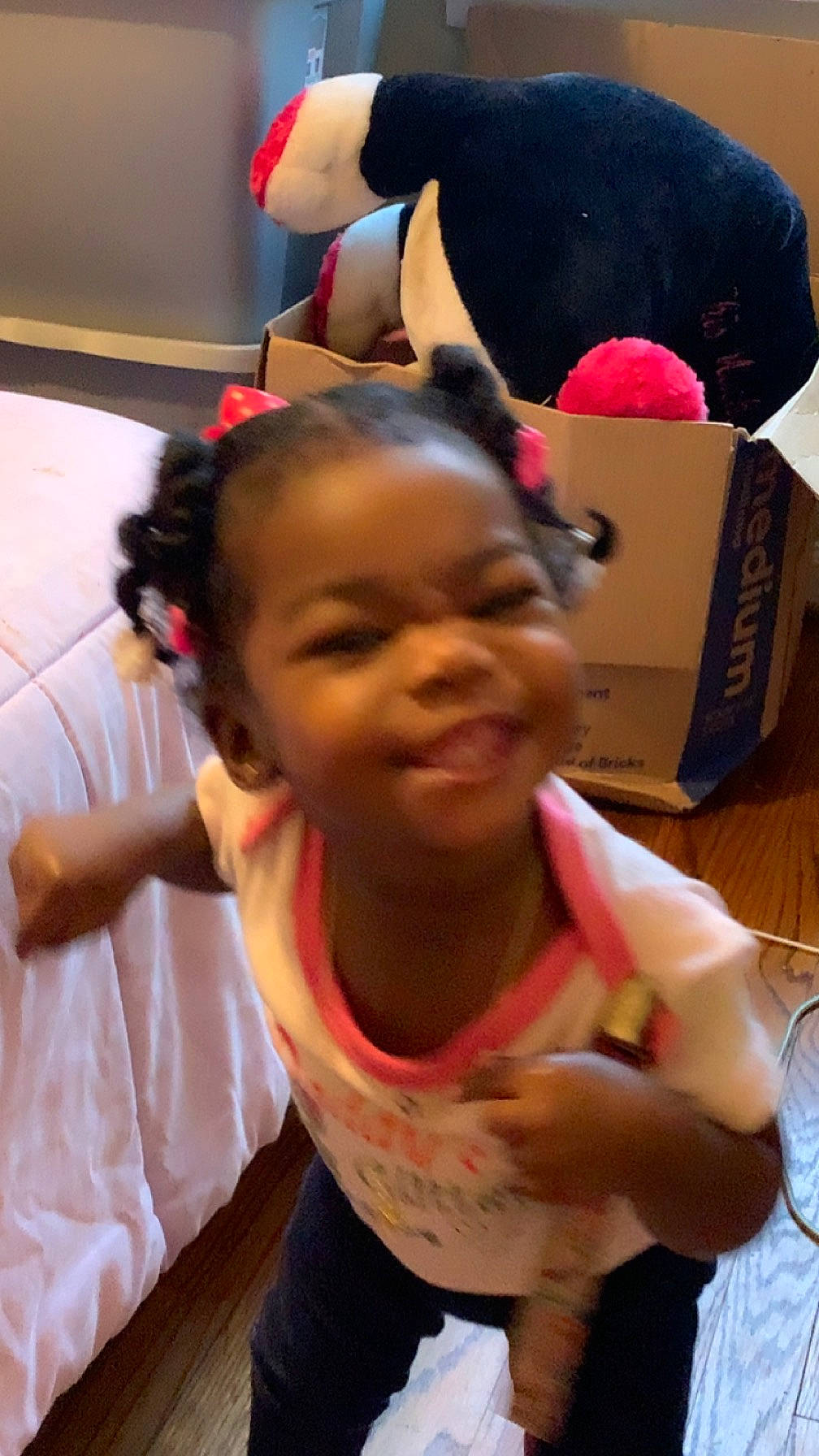 Aliza is registered to the contest to win money with this photo: black_hair, box, carmine, child, ear, event, flooring, fun, happy, joy, magenta, person, room, shipping_box, smile, stuffed_toy, thumb