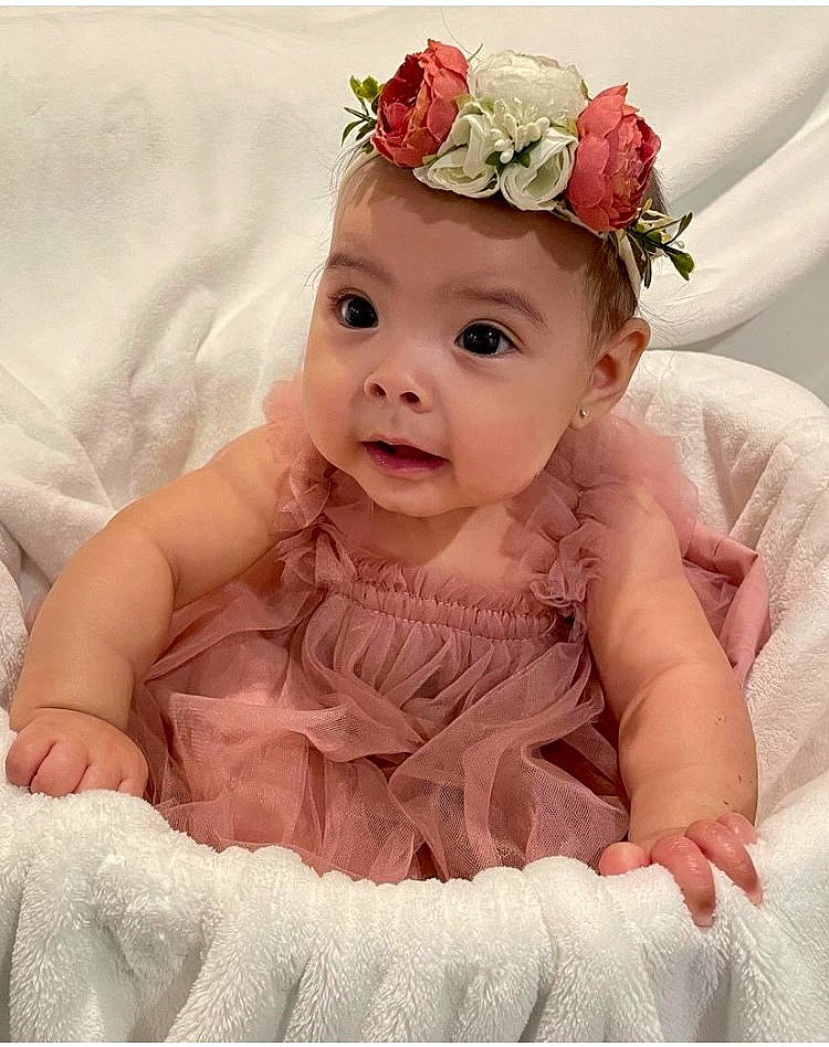 Ellianna is registered to the contest to win money with this photo: baby, baby_toddler_clothing, bridal_accessory, dress, embellishment, flash_photography, flower, happy, headband, headgear, headpiece, headwear, iris, jewellery, person, petal, pink, plant, product, rose