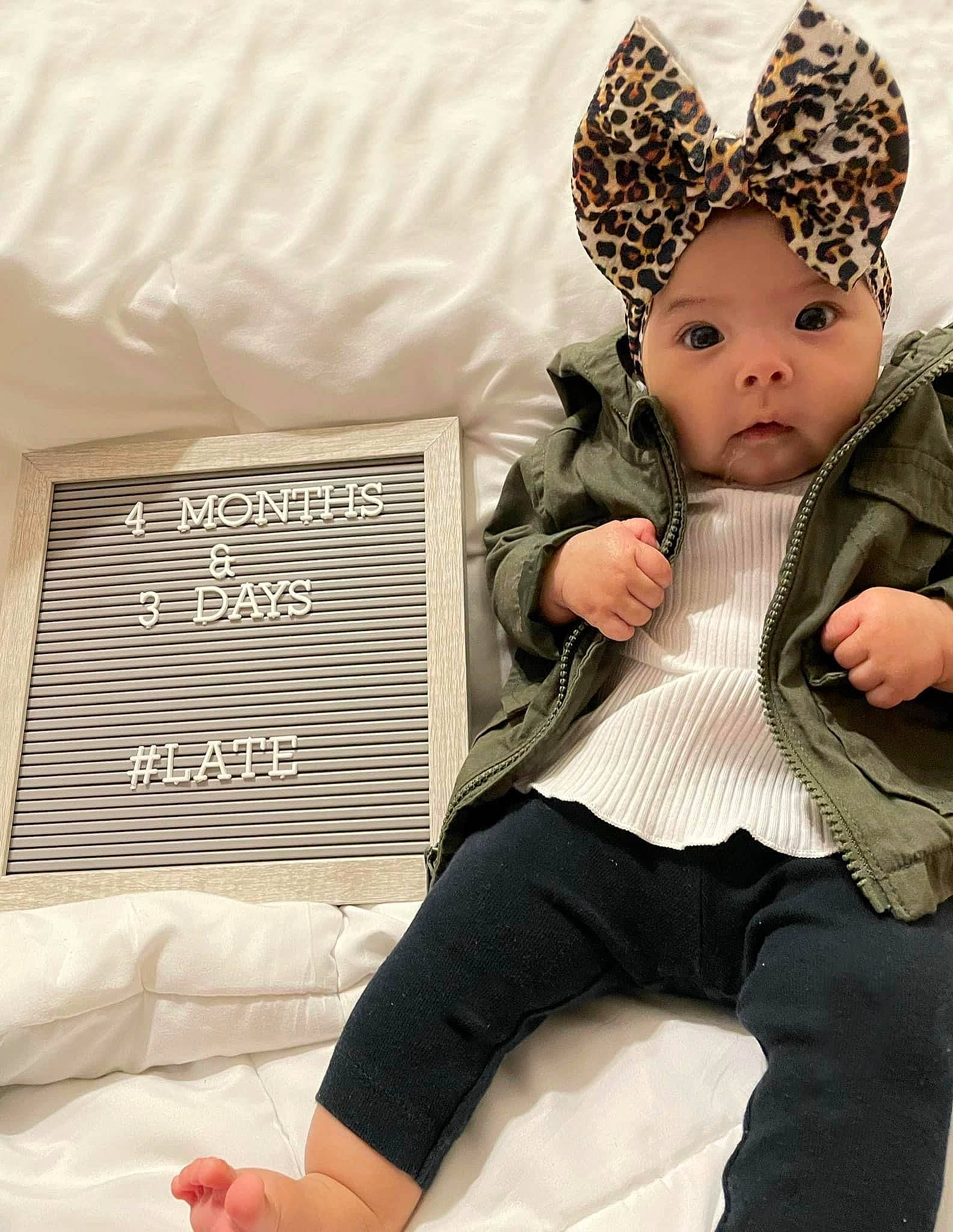 Ellianna is registered to the contest to win money with this photo: baby, baby_toddler_clothing, cap, comfort, costume_hat, fashion_accessory, fur, headpiece, headwear, human_leg, knee, knit_cap, leg, linens, pattern, person, room, sitting, textile, thigh