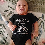 Jimmy is registered to the contest to win money with this photo: baby, bed, black_outfit, blanket, child, clothing, cozy, cute, face, floral_blanket, grinning, happy, indoor, infant, lying_down, onesie, photography, portrait, skeleton_graphic, smiling