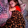 arm, baby_bottle, bed, blanket, child, comfort, cozy, cute, face, hair, indoor, knitted_blanket, leopard_print, peaceful, person, pillow, resting, sleeping, soft, toddler